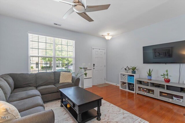 living area with ceiling fan, wood finished floors, and baseboards