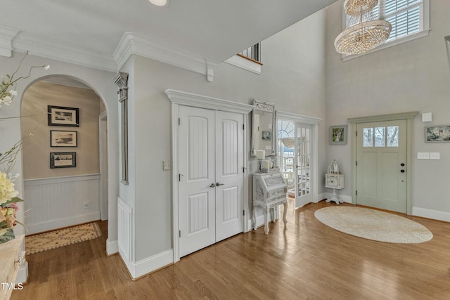 296 Shoreline Dr, Princeton, NC 27569 - foyer entrance featuring crown molding, a wainscoted wall, wood finished floors, arched walkways, and a high ceiling