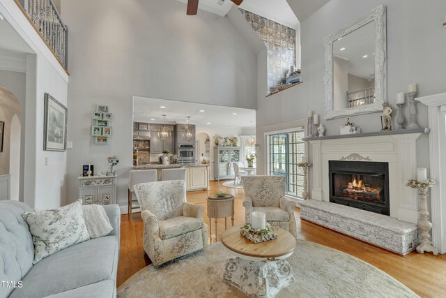 296 Shoreline Dr, Princeton, NC 27569 - living area featuring a lit fireplace, arched walkways, high vaulted ceiling, and wood finished floors
