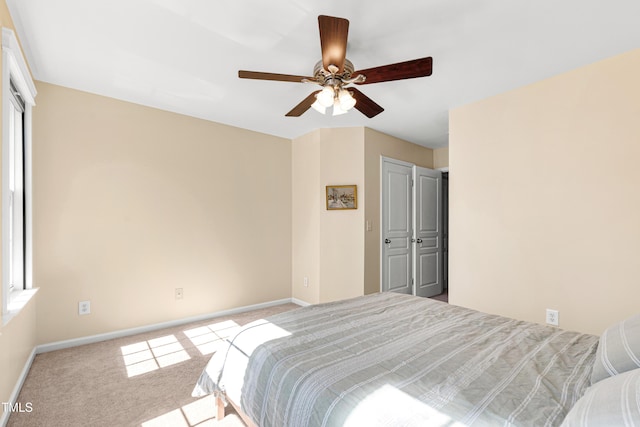 carpeted bedroom featuring baseboards and ceiling fan