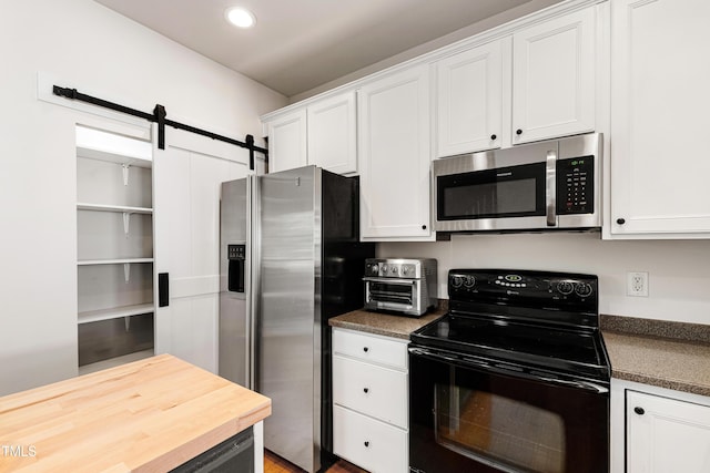 kitchen with stainless steel appliances, white cabinetry, recessed lighting, wooden counters, and a barn door