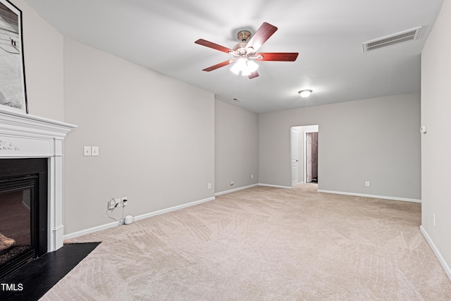 unfurnished living room featuring light colored carpet, a fireplace with flush hearth, a ceiling fan, and baseboards