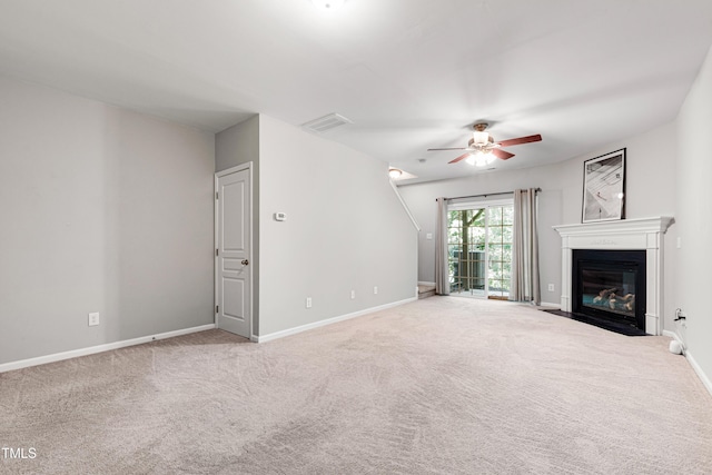 unfurnished living room with a ceiling fan, carpet flooring, baseboards, and a fireplace with flush hearth