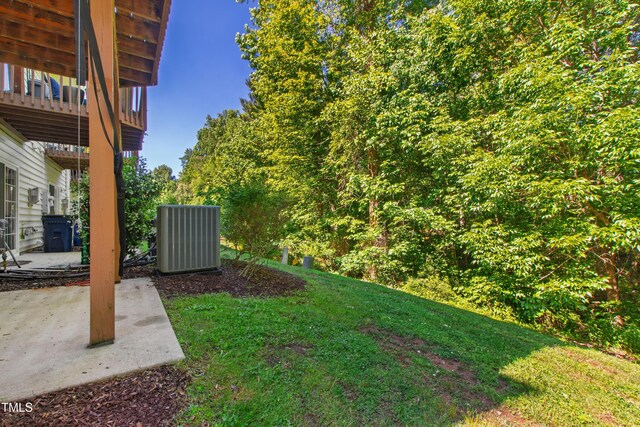 view of green lawn with cooling unit, a patio, and a balcony
