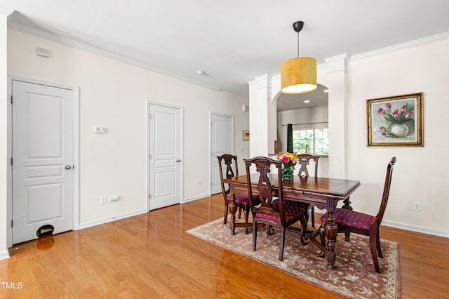 dining area with ornamental molding, light wood-type flooring, and baseboards
