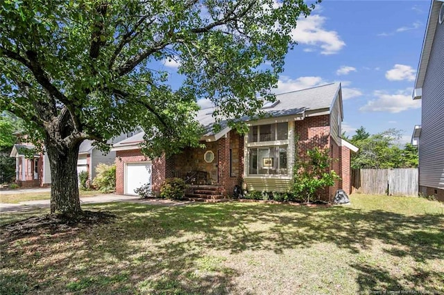 view of front of house with a garage, fence, concrete driveway, a front yard, and brick siding