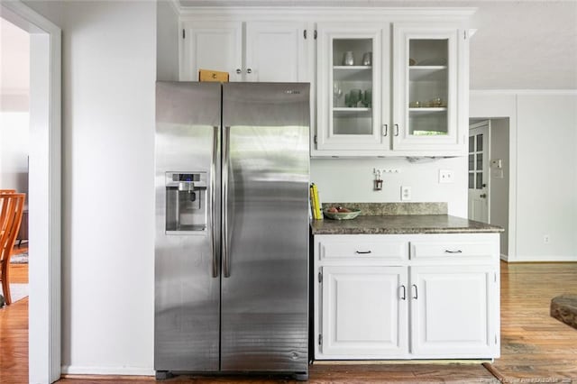 kitchen with wood finished floors, white cabinetry, glass insert cabinets, stainless steel fridge with ice dispenser, and dark countertops