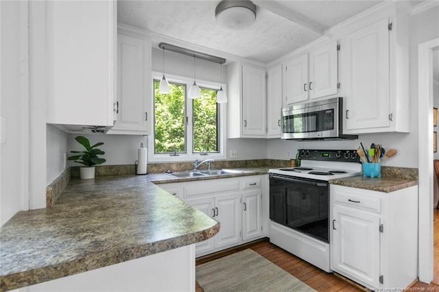 kitchen featuring a sink, stainless steel microwave, white cabinetry, dark countertops, and electric range