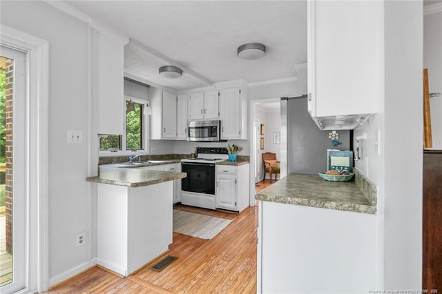 kitchen featuring white cabinets, light wood-type flooring, stainless steel microwave, range with electric stovetop, and ornamental molding