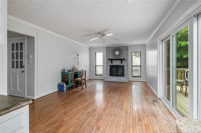 unfurnished living room with light wood finished floors, crown molding, and a ceiling fan