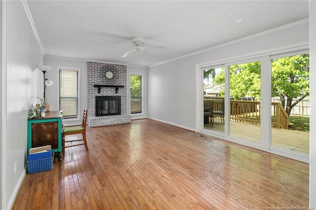 unfurnished living room with ceiling fan, plenty of natural light, hardwood / wood-style floors, and ornamental molding