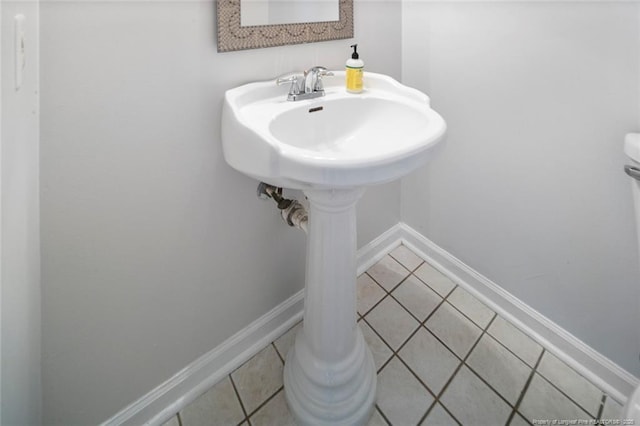 bathroom with baseboards and tile patterned floors