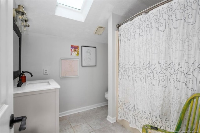 full bath with toilet, a shower with shower curtain, a skylight, baseboards, and vanity