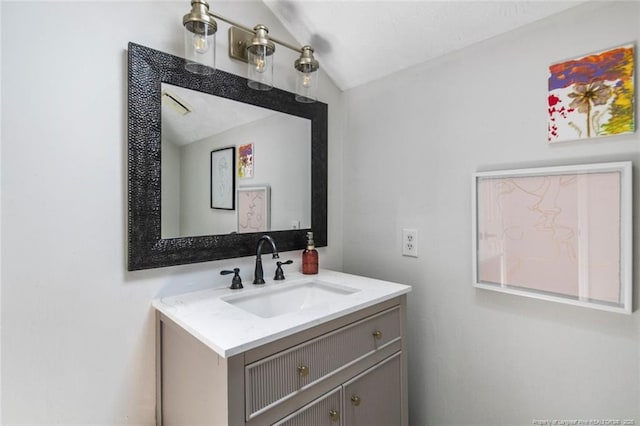 bathroom featuring vaulted ceiling and vanity