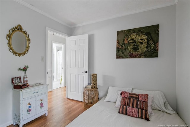 bedroom featuring crown molding and wood finished floors