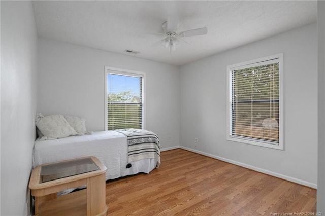 bedroom with ceiling fan, baseboards, visible vents, and light wood-style floors
