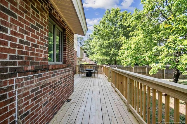 deck with outdoor dining area and fence