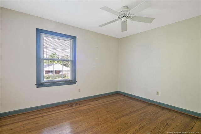 unfurnished room featuring wood finished floors, baseboards, and ceiling fan