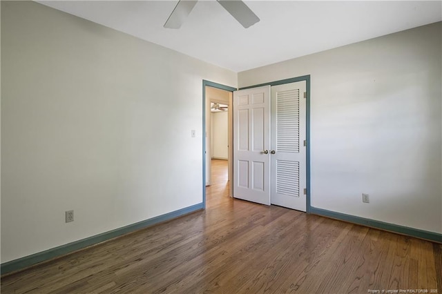 unfurnished bedroom with baseboards, a closet, ceiling fan, and wood finished floors
