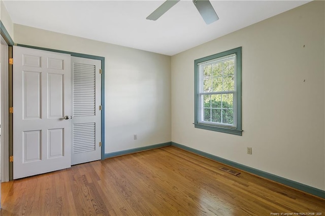 unfurnished bedroom featuring a closet, visible vents, wood finished floors, and baseboards