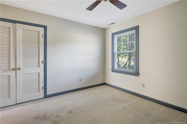 unfurnished bedroom with a ceiling fan, a closet, baseboards, carpet flooring, and visible vents