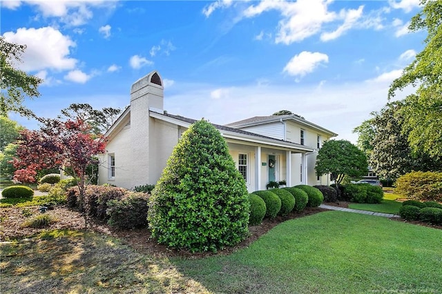 view of side of property featuring a yard and a chimney