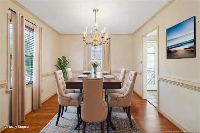dining area with crown molding, a chandelier, wood finished floors, and baseboards