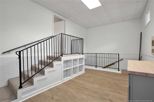 stairway featuring a drop ceiling and wood finished floors