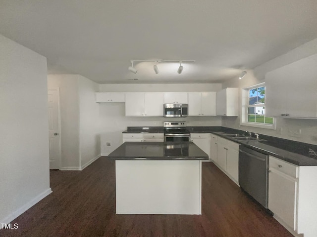 4126 Amber Stone Way, Durham, NC 27704 - kitchen with a sink, rail lighting, white cabinetry, dark countertops, and appliances with stainless steel finishes