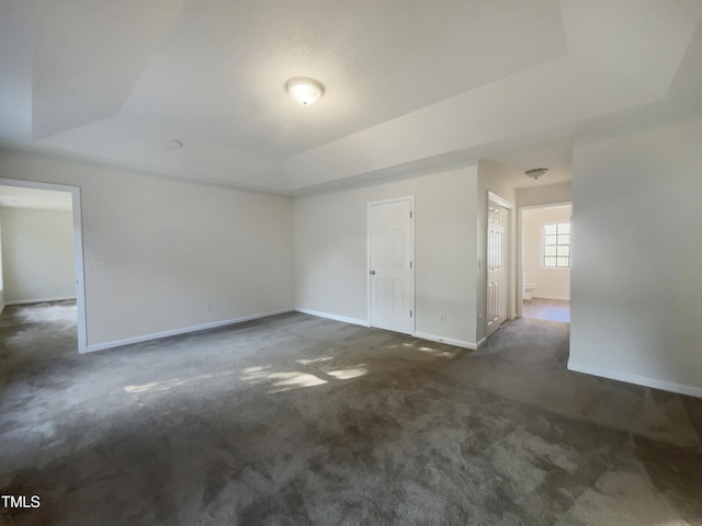 4126 Amber Stone Way, Durham, NC 27704 - spare room with dark carpet, a raised ceiling, and baseboards