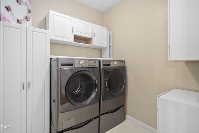 laundry area with separate washer and dryer, cabinet space, and baseboards