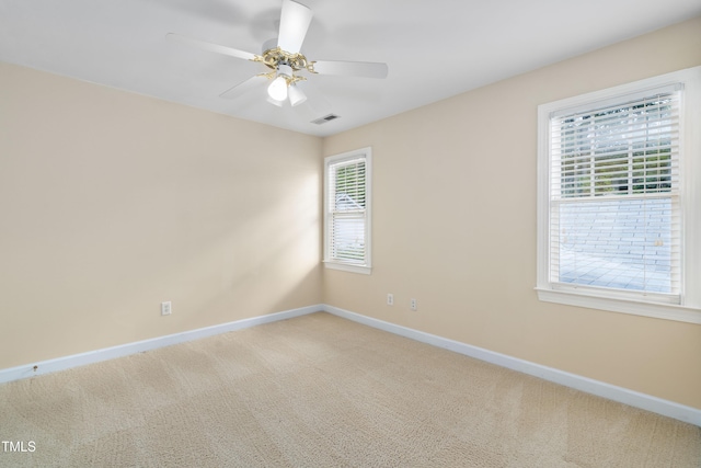 empty room featuring baseboards, light carpet, and a ceiling fan