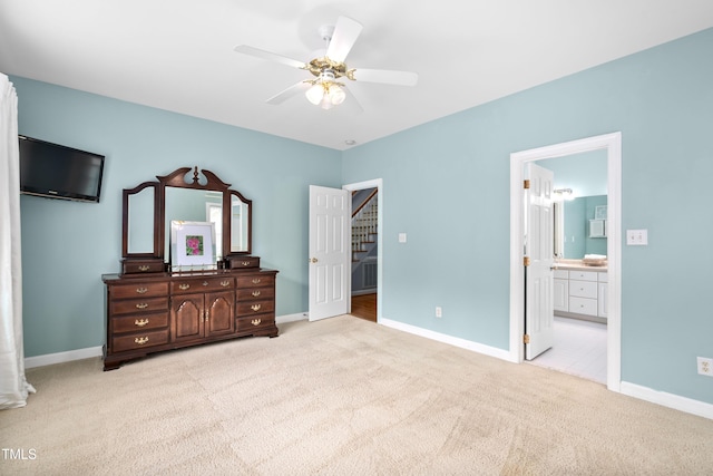 bedroom with light colored carpet, baseboards, ensuite bathroom, and a ceiling fan