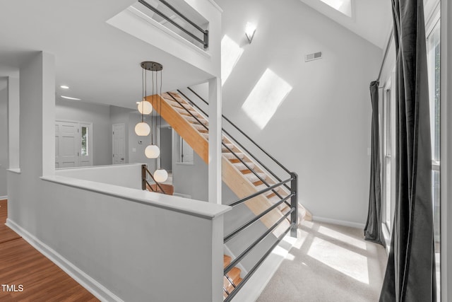 stairway featuring wood finished floors, baseboards, visible vents, and recessed lighting