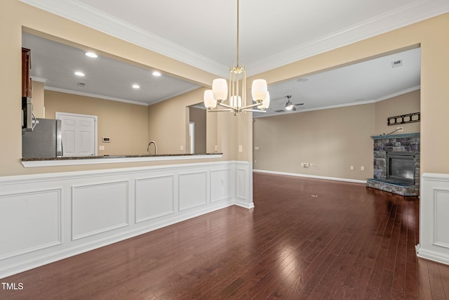 507 Brier Crossings Loop, Durham, NC 27703 - kitchen featuring a fireplace, stainless steel appliances, a chandelier, pendant lighting, and crown molding