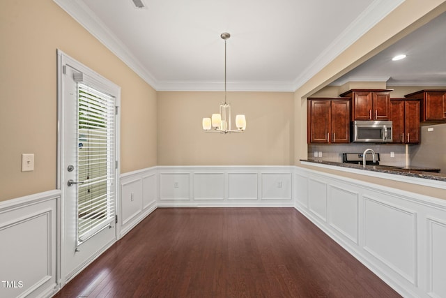 507 Brier Crossings Loop, Durham, NC 27703 - kitchen featuring stainless steel microwave, a chandelier, dark wood-style flooring, crown molding, and a wainscoted wall