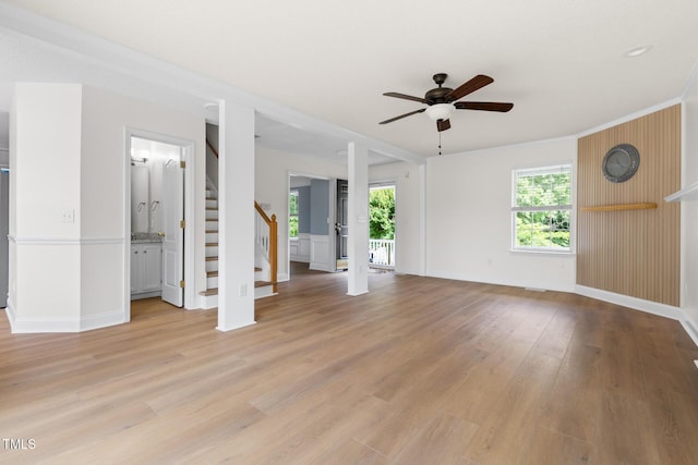 59 Troy Dr, Fuquay Varina, NC 27526 - unfurnished living room featuring stairway, light wood finished floors, a ceiling fan, baseboards, and ornamental molding