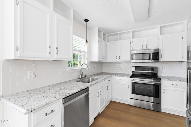 59 Troy Dr, Fuquay Varina, NC 27526 - kitchen featuring stainless steel appliances, a sink, white cabinets, light stone countertops, and pendant lighting