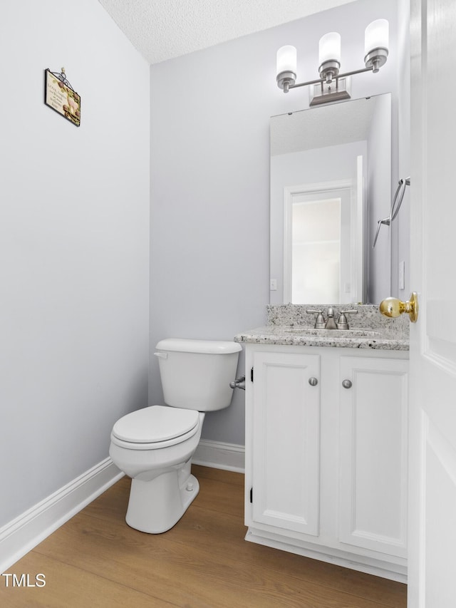 59 Troy Dr, Fuquay Varina, NC 27526 - bathroom featuring baseboards, toilet, wood finished floors, and vanity
