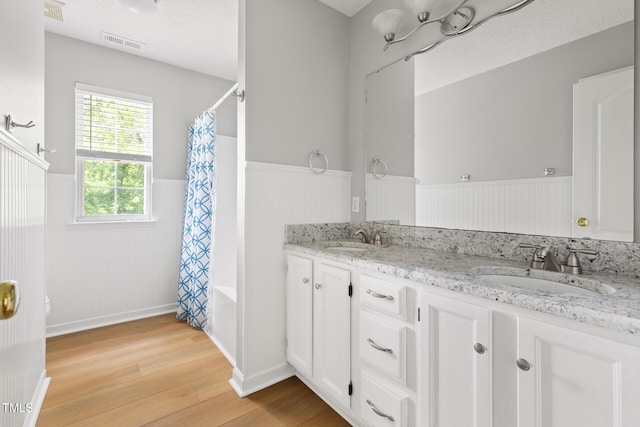 59 Troy Dr, Fuquay Varina, NC 27526 - full bathroom featuring wainscoting, wood finished floors, double vanity, and shower / tub combo with curtain