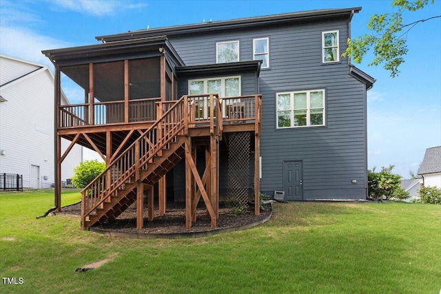 rear view of property featuring a sunroom, a lawn, stairs, and a deck
