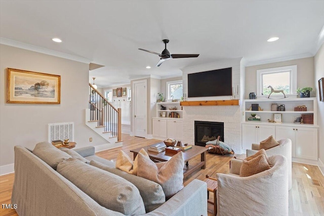 living area with ornamental molding, recessed lighting, stairway, a ceiling fan, and light wood finished floors