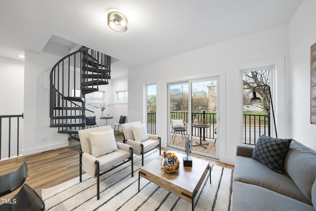 living room featuring wood finished floors, stairs, and baseboards