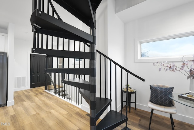 staircase with wood finished floors and baseboards