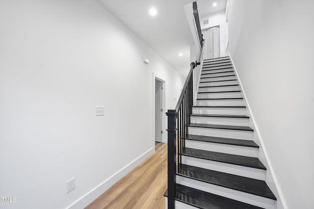 staircase featuring recessed lighting, wood finished floors, and baseboards