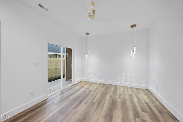 unfurnished room featuring wood finished floors, a ceiling fan, and baseboards