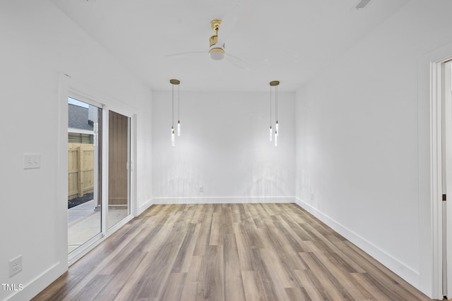 unfurnished dining area with wood finished floors, a ceiling fan, and baseboards