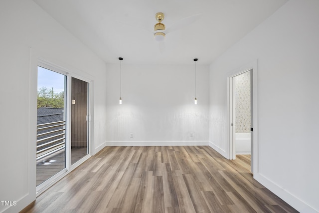 spare room featuring wood finished floors, baseboards, and a ceiling fan