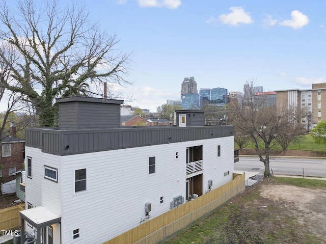 back of property with fence and a chimney