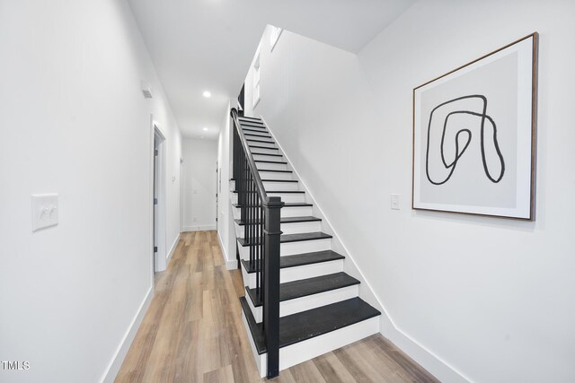 stairway featuring baseboards, recessed lighting, and wood finished floors